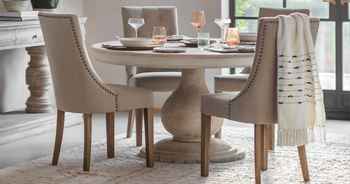 A selection of stylish dining chairs arranged around a wooden dining table in a bright, modern interior.